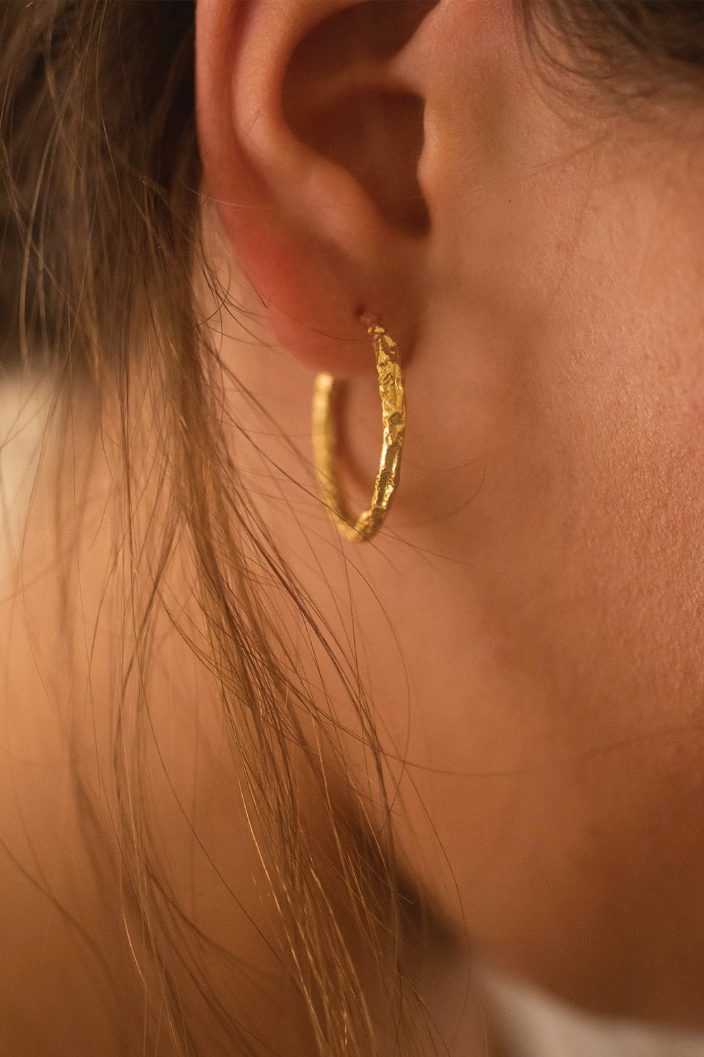 Medium gold hoops worn on the ear – Vessaly