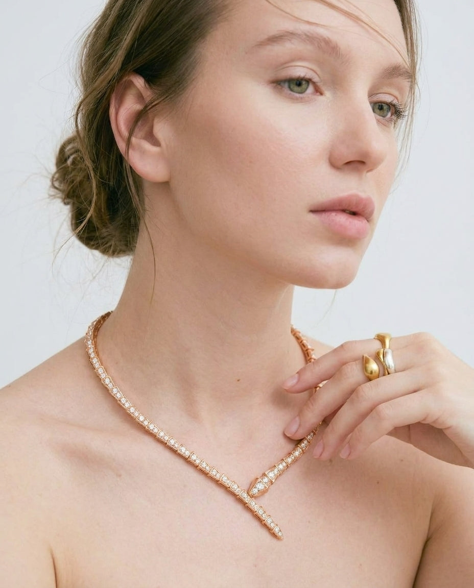 Close-up of gold snake necklace with white crystals – Vessaly