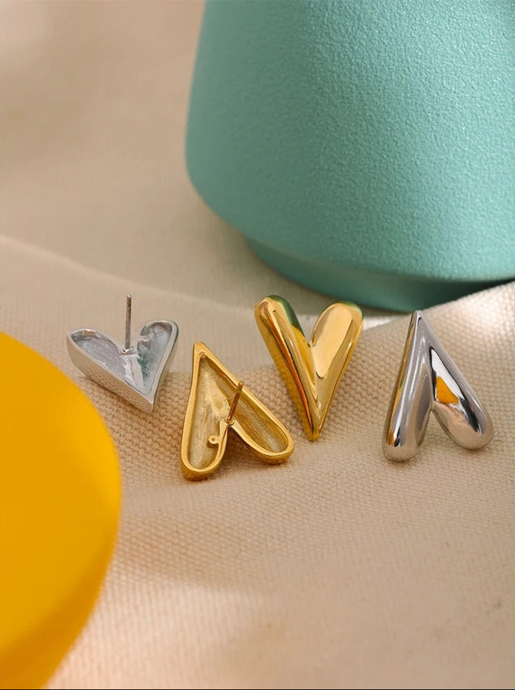 Gold heart drop earrings shown with elegant outfit