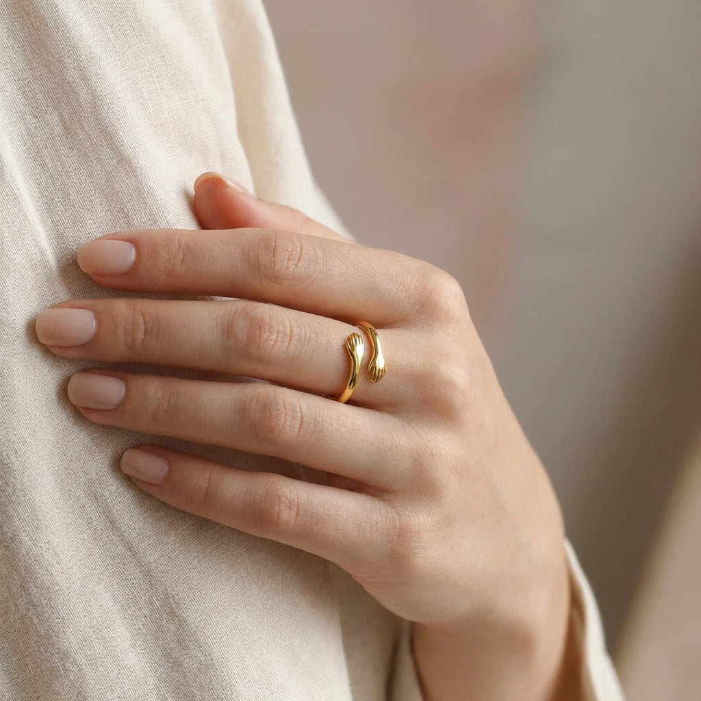 Hug-inspired gold ring on neutral background