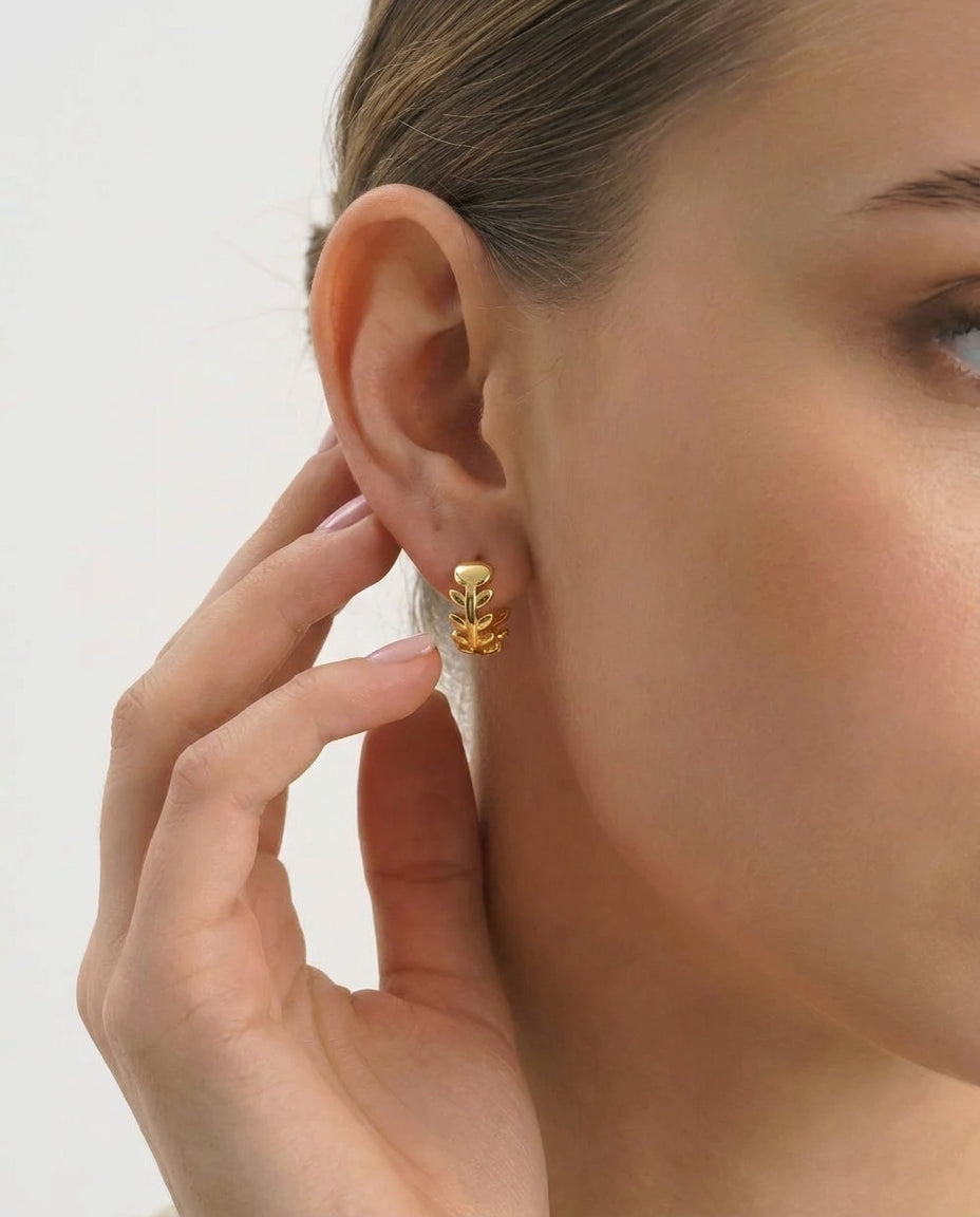 14K gold-plated huggie earrings on neutral background