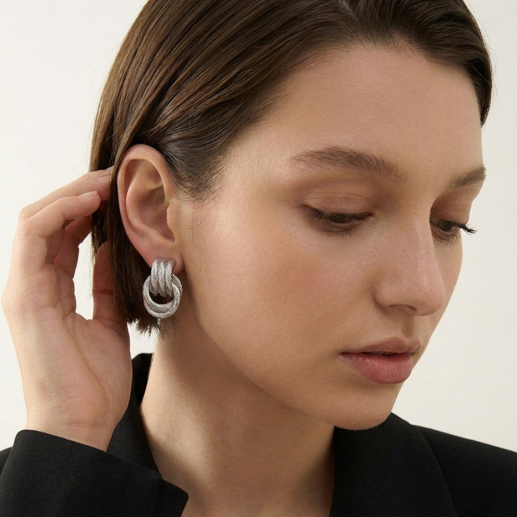 Giro Bella knot earrings on neutral background
