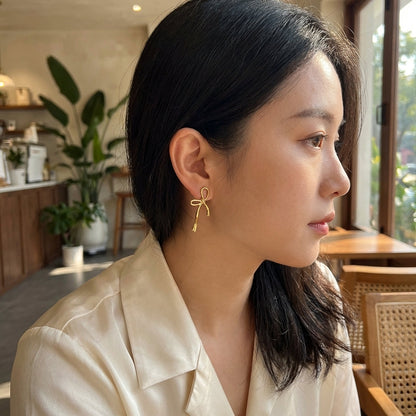 Gold bow drop earrings – side view