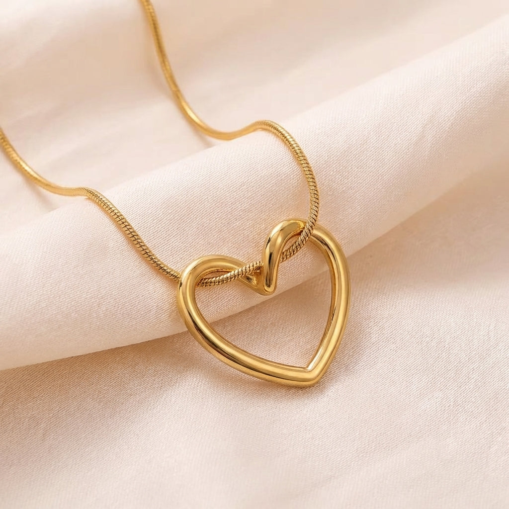 Gold heart necklace styled with an outfit – Vessaly