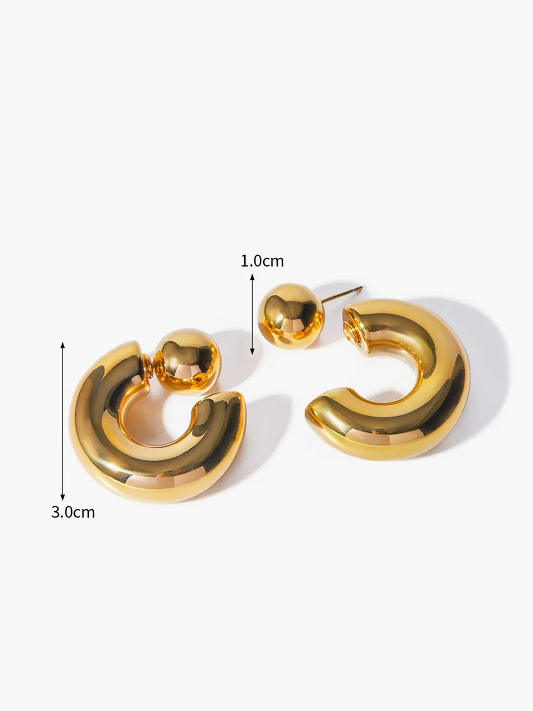 Close-up of C-shaped earring — smooth curved detail, gold tone