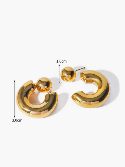Close-up of C-shaped earring — smooth curved detail, gold tone