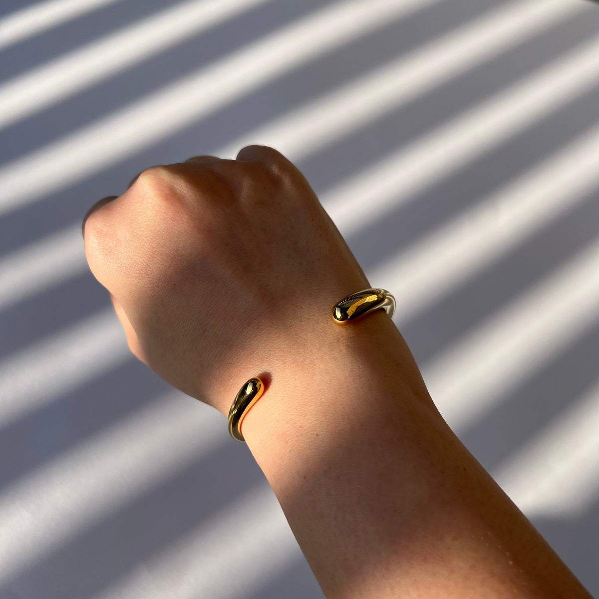 Gold cuff bracelet worn on the wrist – Vessaly