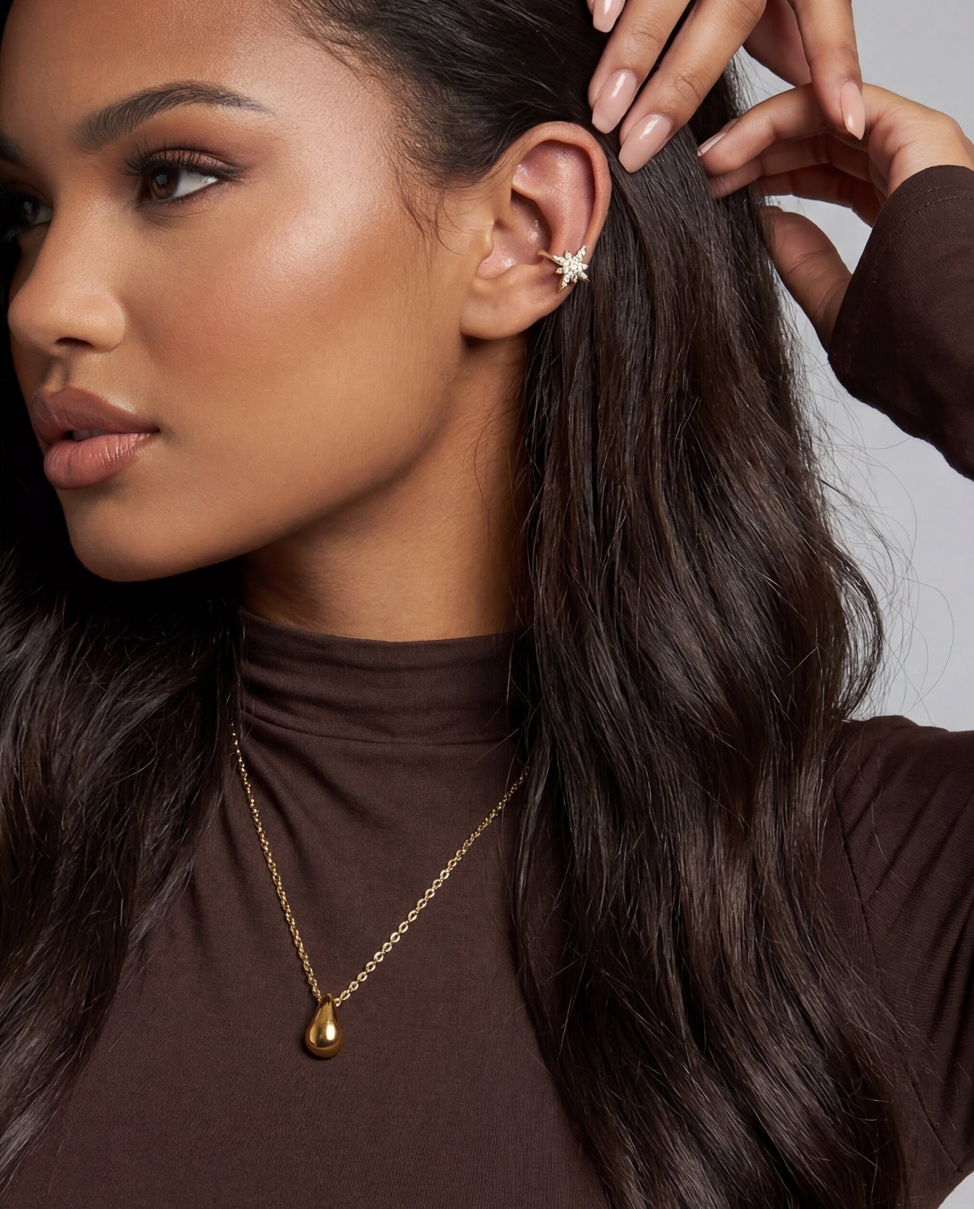 Adjustable gold teardrop necklace on neutral background