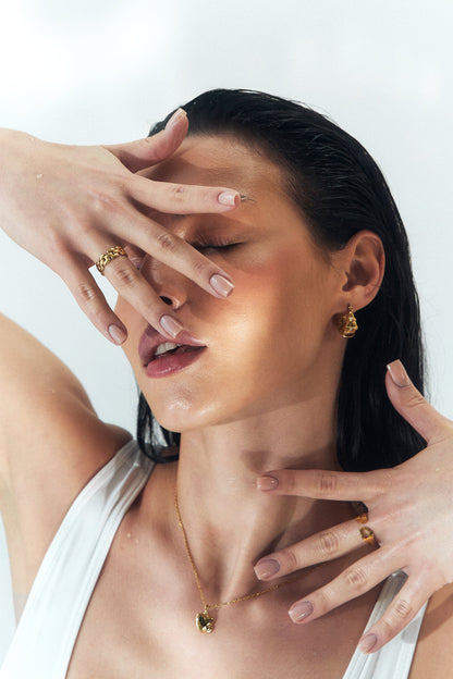 Gold teardrop hoops worn on the ear – Vessaly