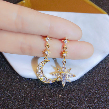 Moon and star drop earrings worn on the ear – Vessaly