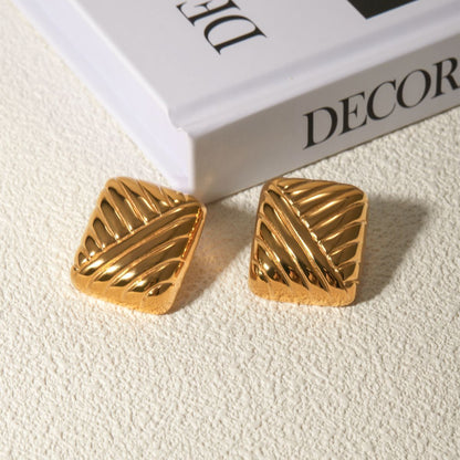 Gioiello gold earrings on neutral background