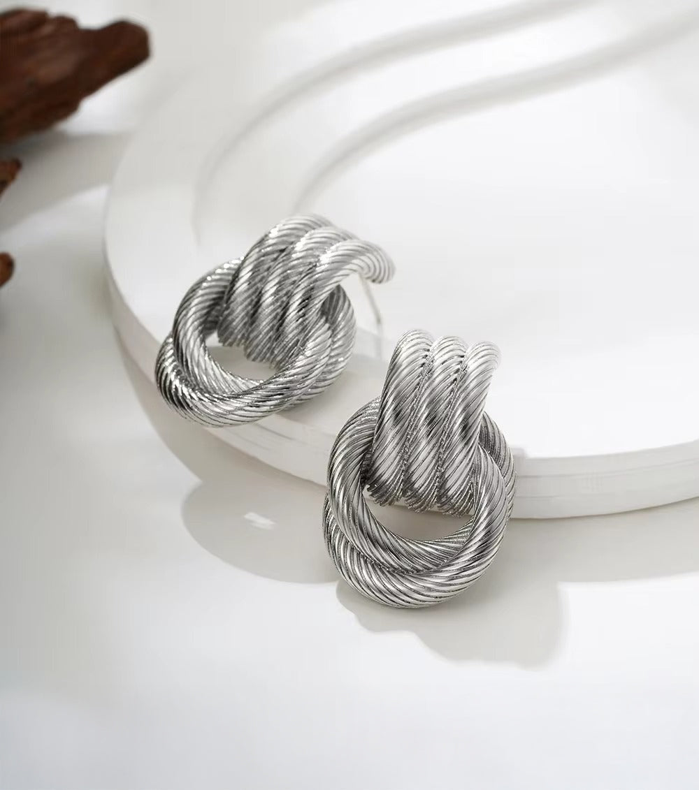 Knot earrings shown with elegant outfit styling