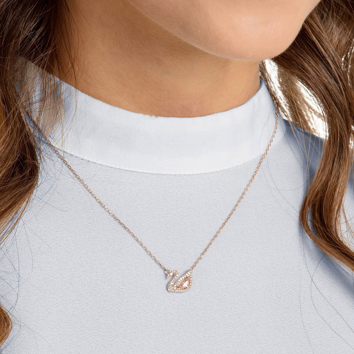 Rose gold swan necklace styled on neckline – Vessaly