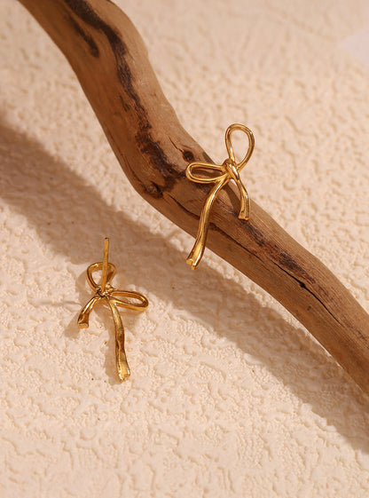 Delicate gold bow earrings – texture detail