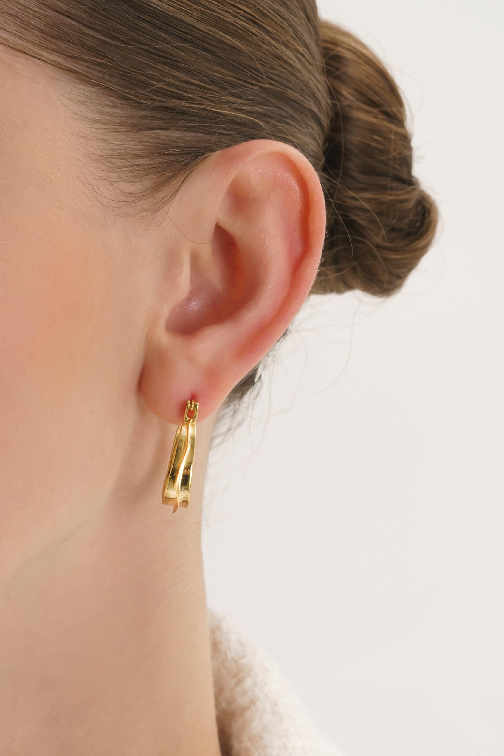 Bold oval gold hoop earrings – close-up detail