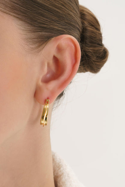 Bold oval gold hoop earrings – close-up detail