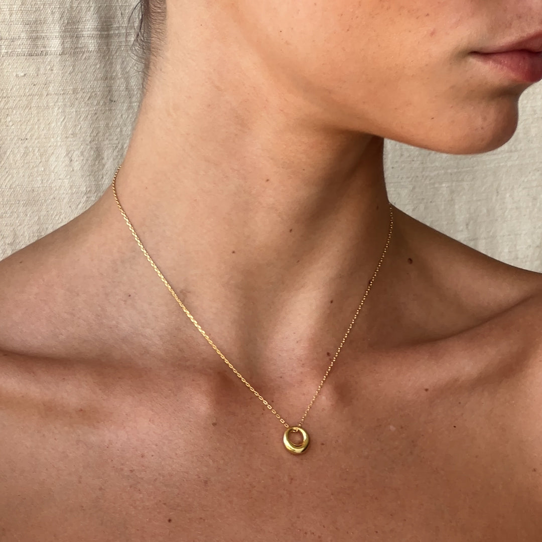 Close-up of tapered gold circle pendant – Vessaly
