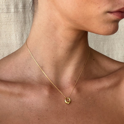 Close-up of tapered gold circle pendant – Vessaly
