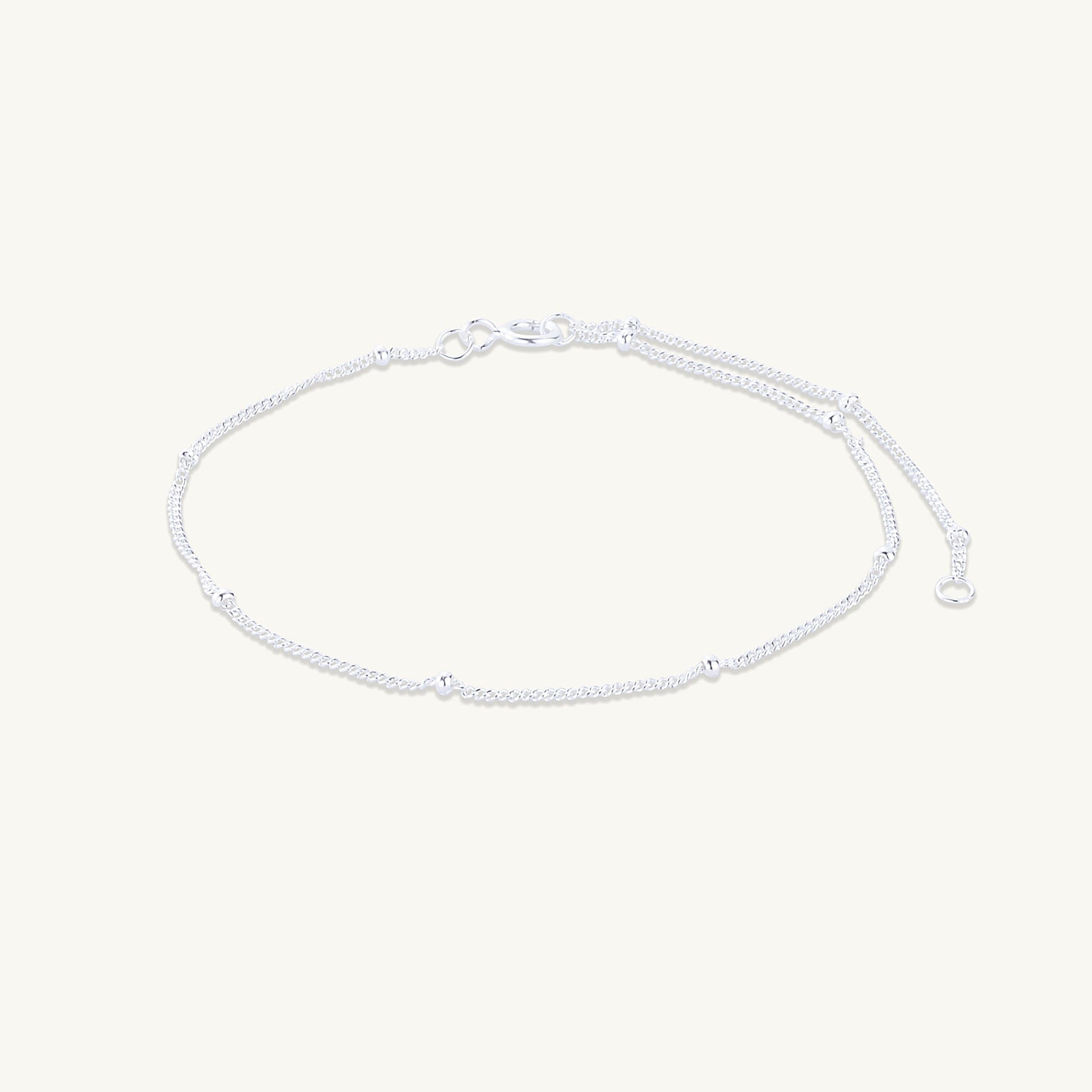 Gold satellite chain bracelet on neutral background