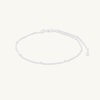 Gold satellite chain bracelet on neutral background