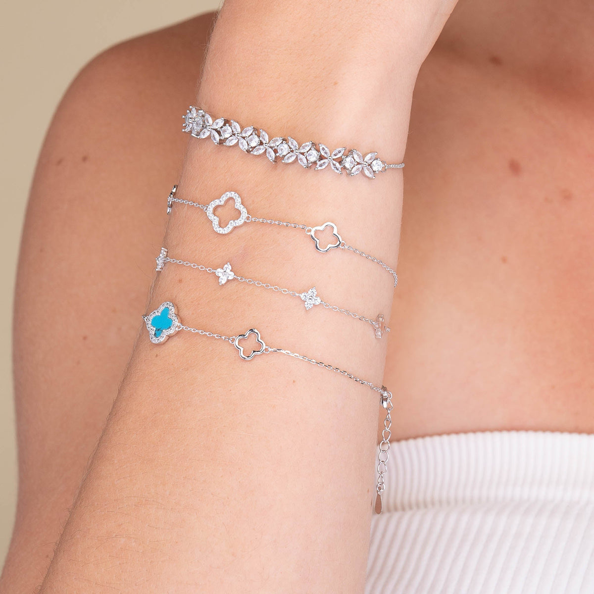 Clover charm bracelet shown with elegant outfit