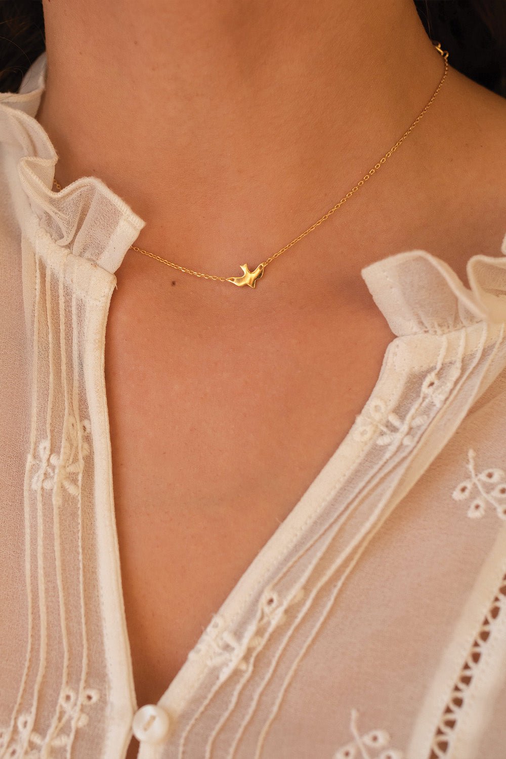 Gold bird choker shown off-centre on the neck