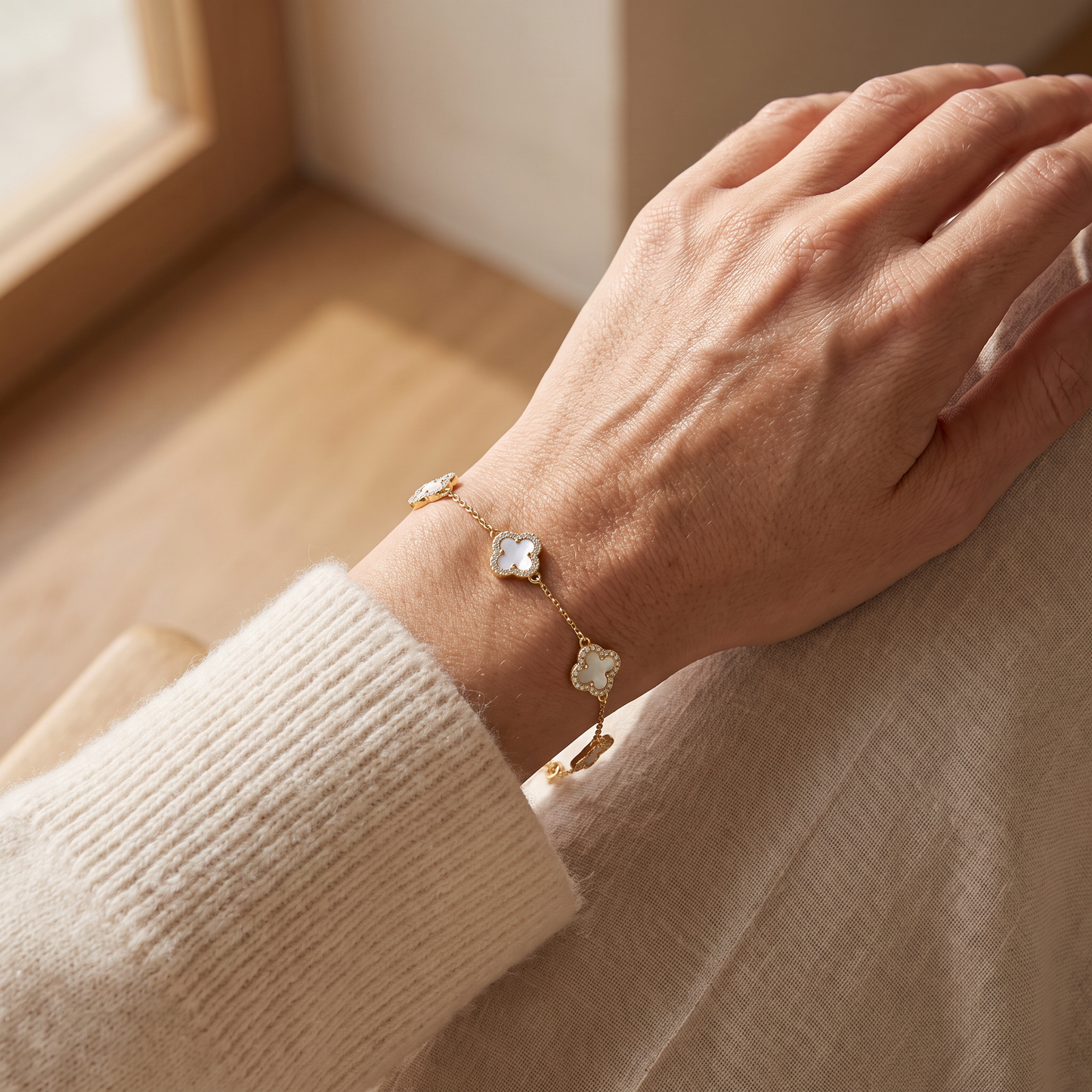 Ravyena clover mother-of-pearl bracelet worn on a woman's wrist in natural daylight