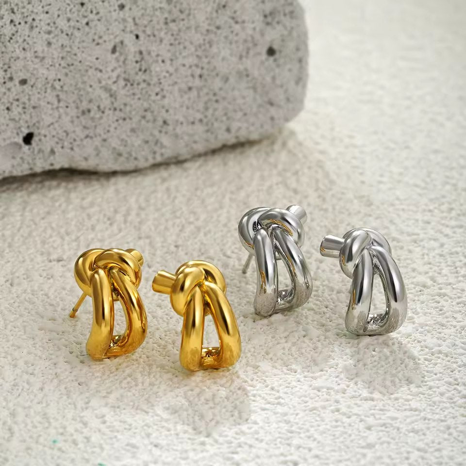 Close-up of silver knot huggie earring detail