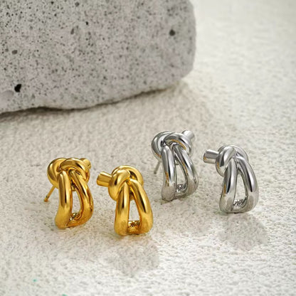 Close-up of silver knot huggie earring detail