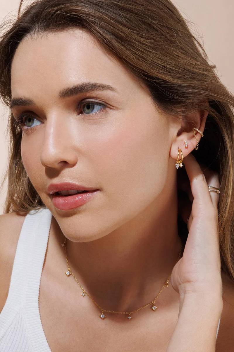 Gold star necklace styled on neckline – Vessaly
