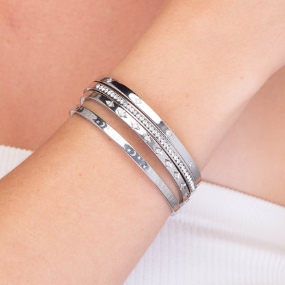 Gold bangle with clover detail, refined finish