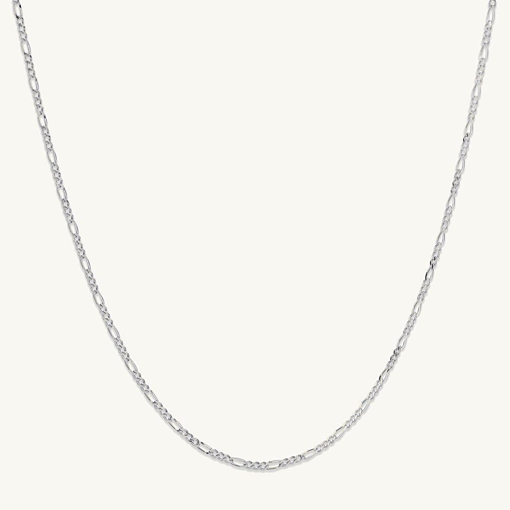Gold figaro chain on neutral background