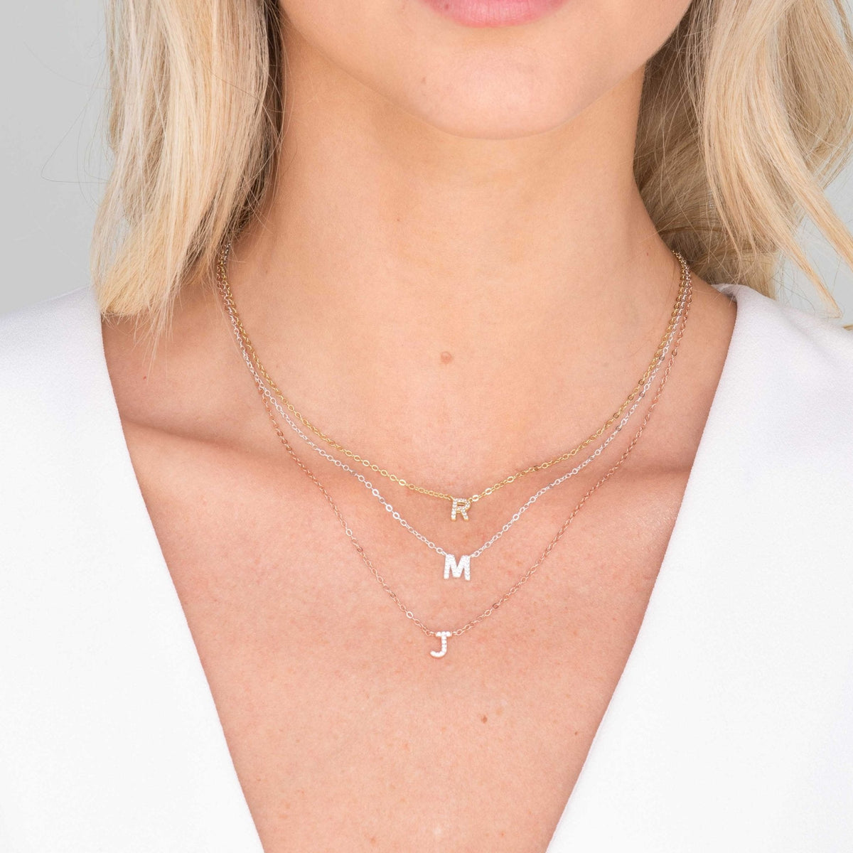 Sapphire initial necklace styled on neckline – Vessaly