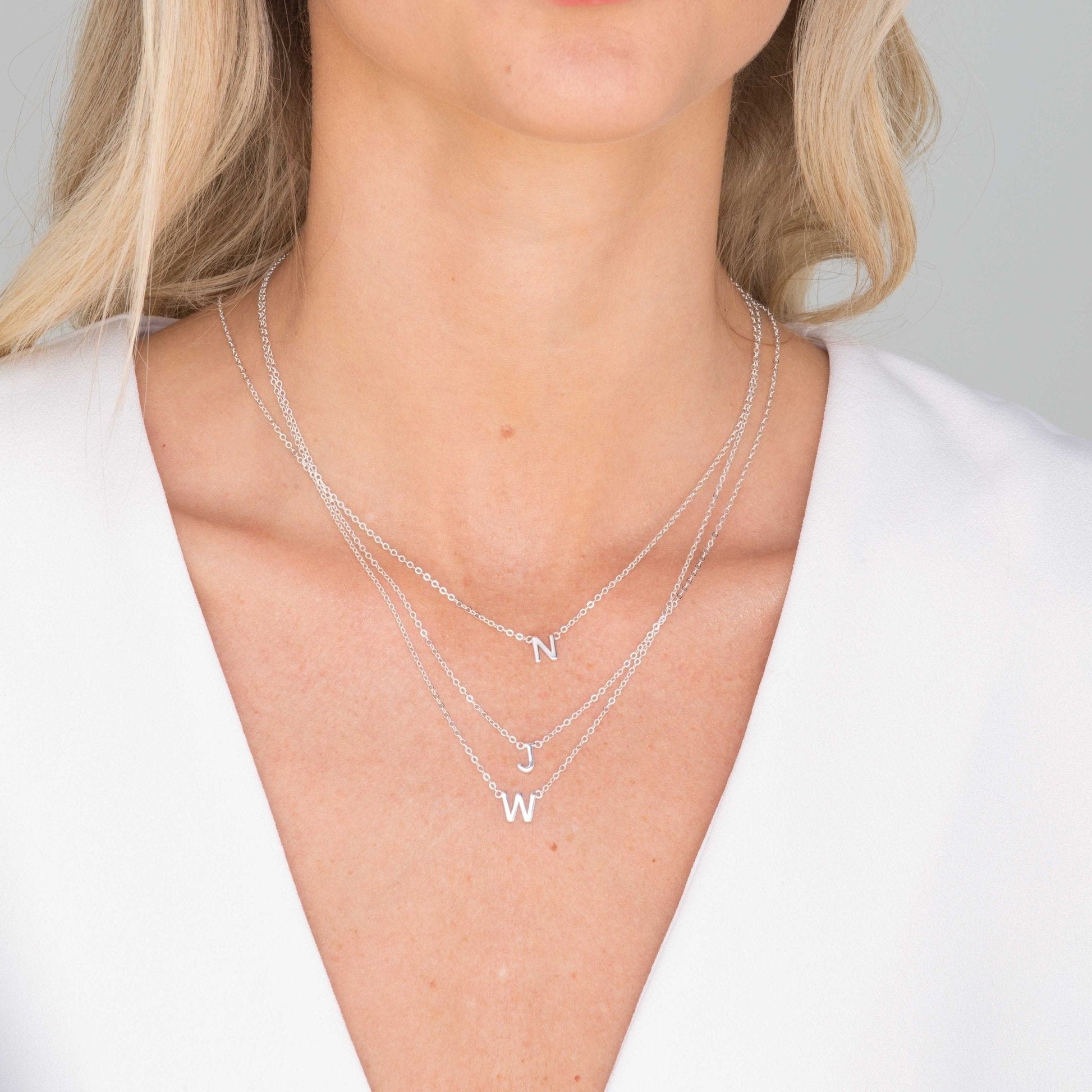 Initial necklace shown layered with other delicate chains