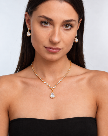 Crystal Teardrop Necklace & Earring Set in Gold / Clear, worn by a model in a front portrait - Vessaly
