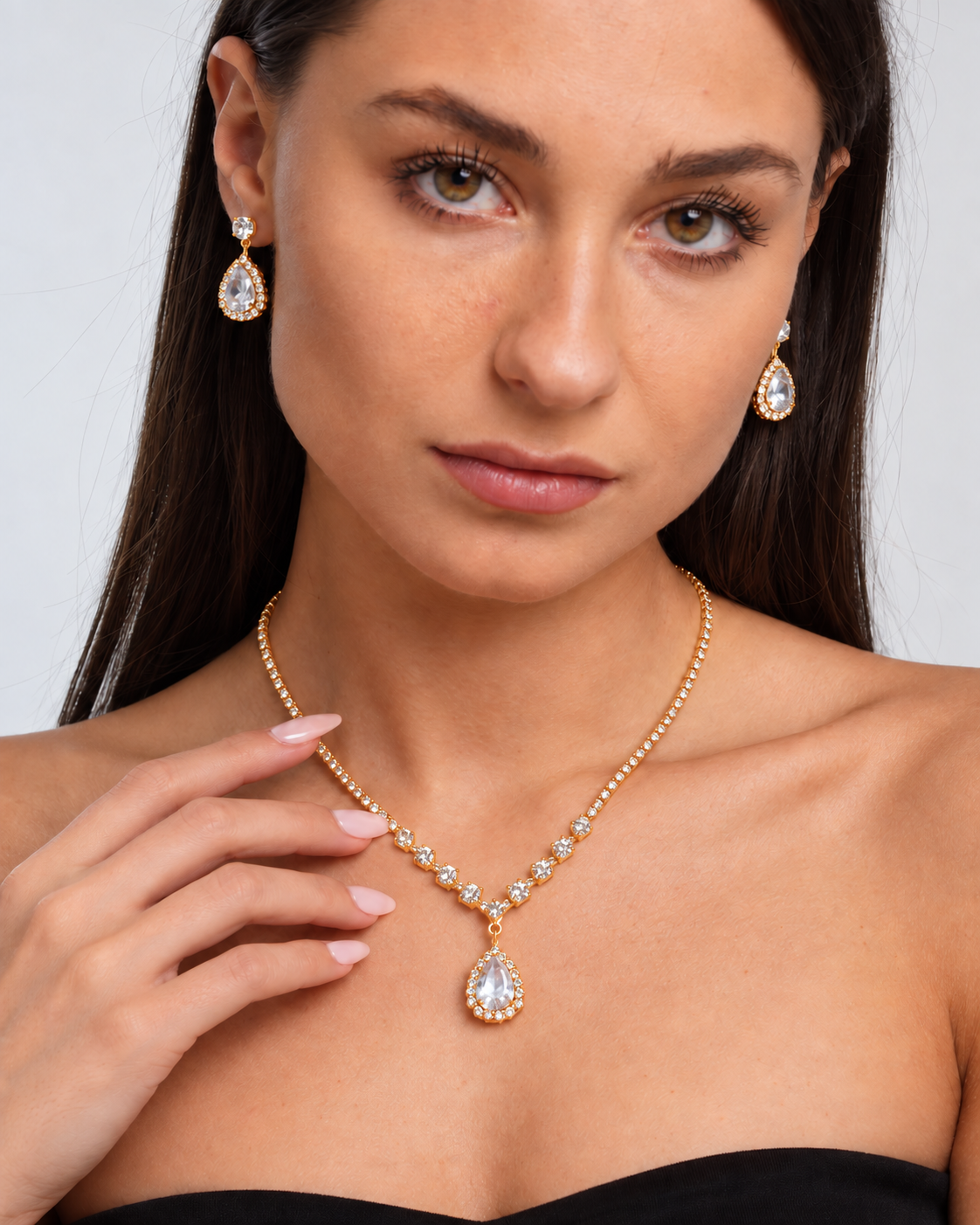 Crystal Teardrop Necklace & Earring Set in Gold / Clear, worn by a model in a close-up - Vessaly