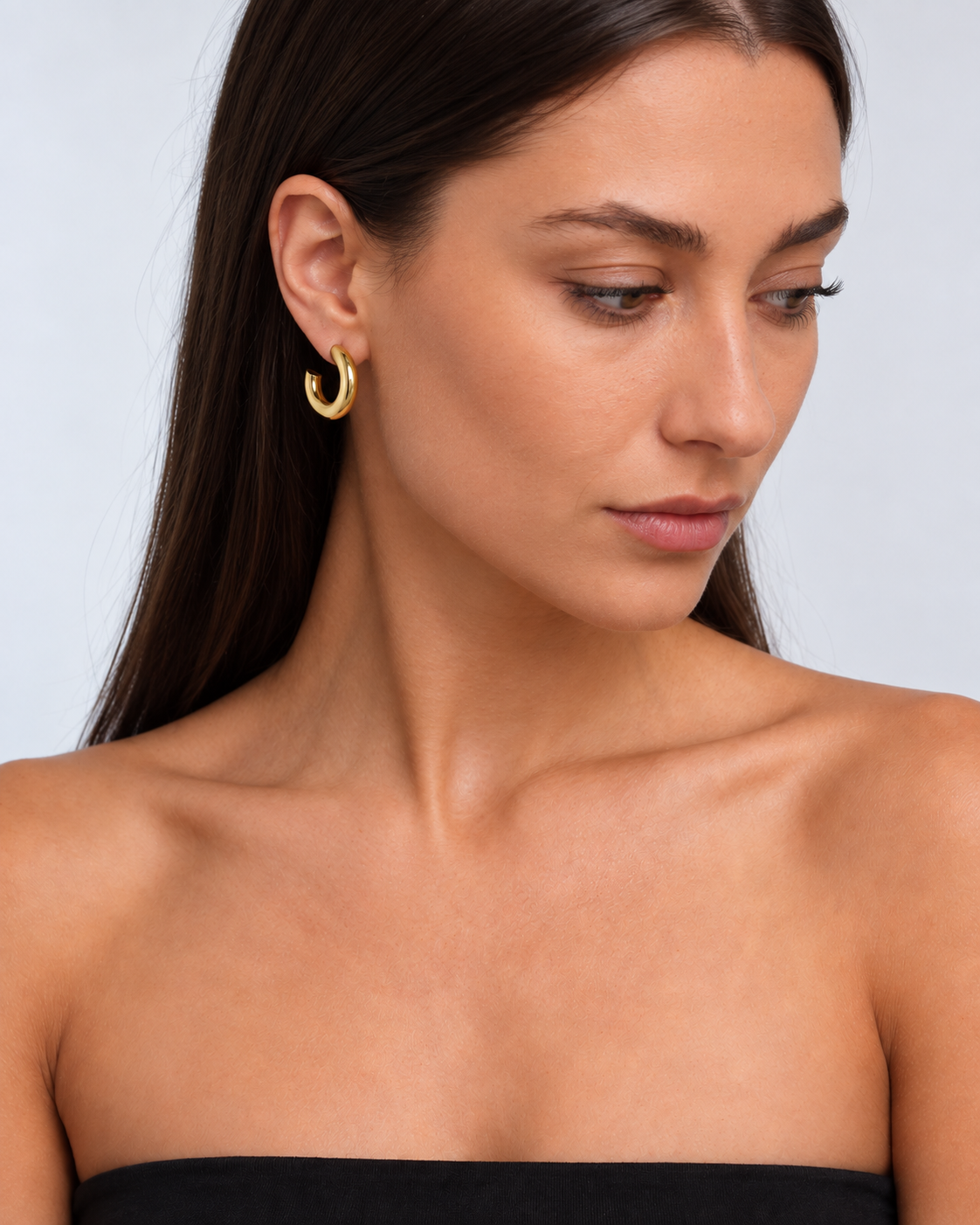 Chunky 14K gold-plated statement hoop earrings worn by a brunette model - side profile